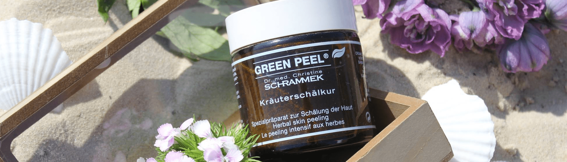 two women with a mud mask on their faces and one older woman holding a jar of dr.schrammek green peel mask.